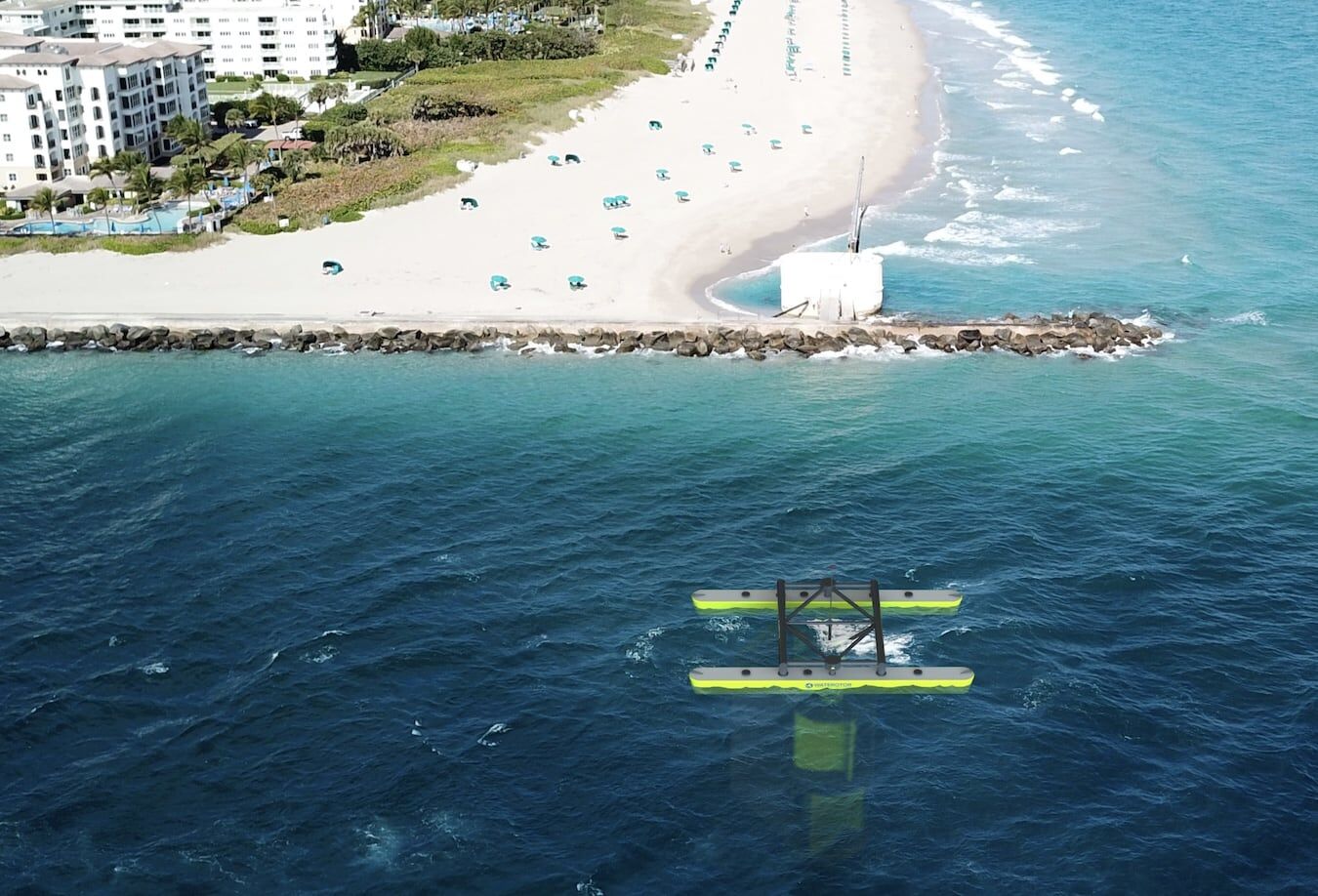 Aerial rendering of a Waterotor tidal platform offshore from a sandy beach and hotels