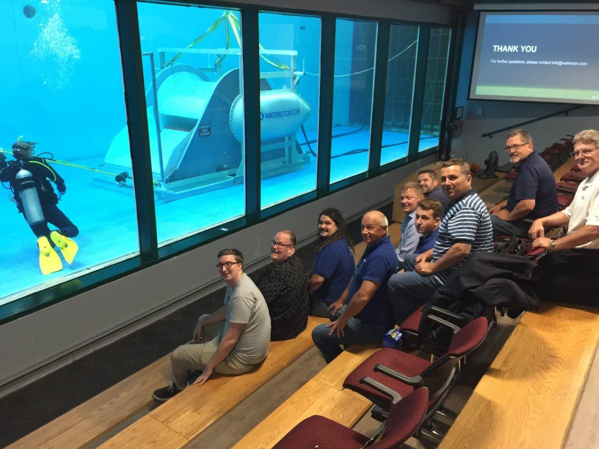 The Waterotor team seated at the flume tank viewing gallery while a diver works beside the unit