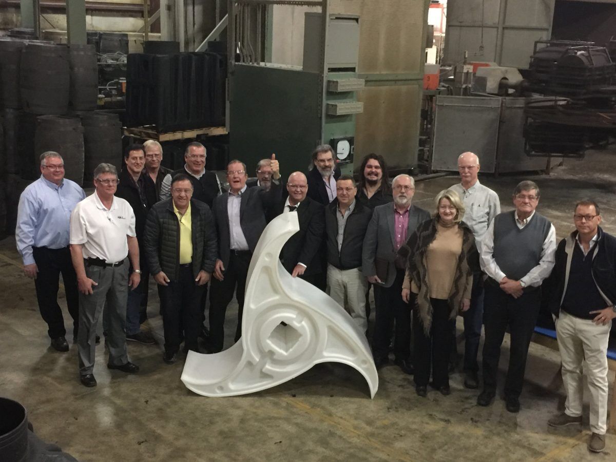 The Waterotor team and partners gathered around a white Waterotor blade in a workshop