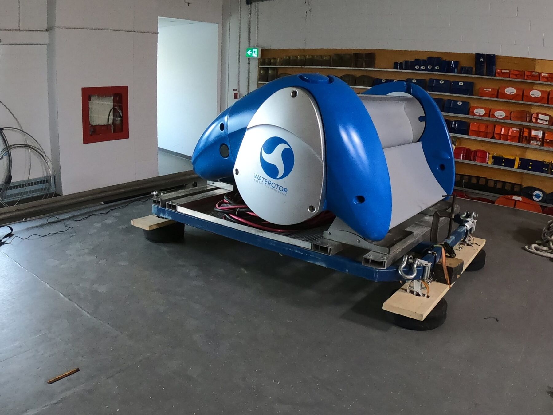 A large blue and white Waterotor unit on a trailer inside a workshop